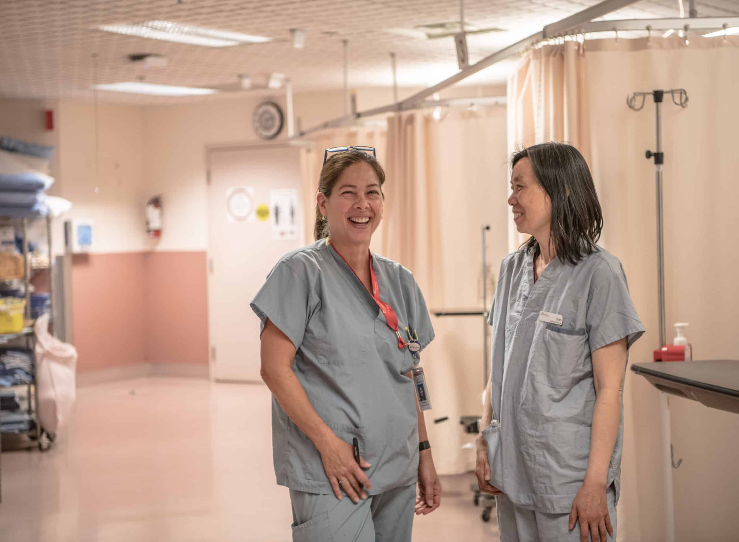 Image of two nurses wearing scrubs and smiling