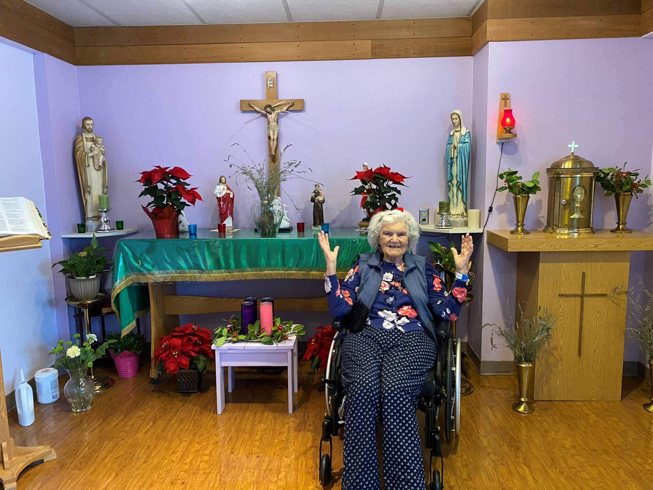 Norma honours her lord at Christmas with poinsettias in the chapel at Holy Family Hospital in Vancouver
