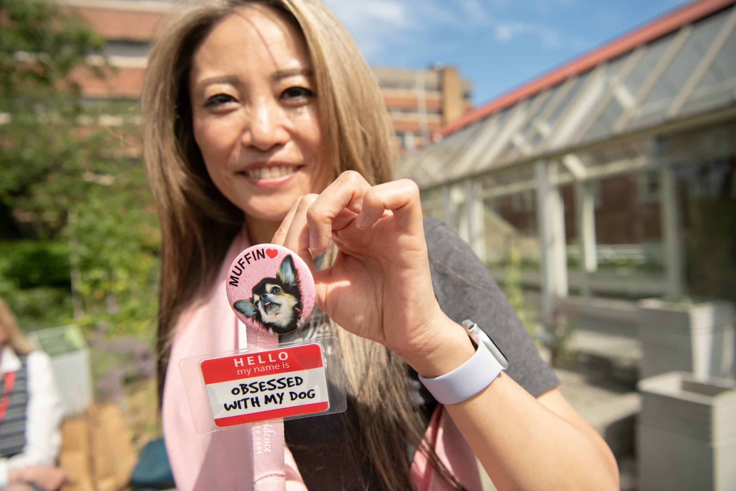 An addiction care support worker proudly showing off her therapy dog's badge.