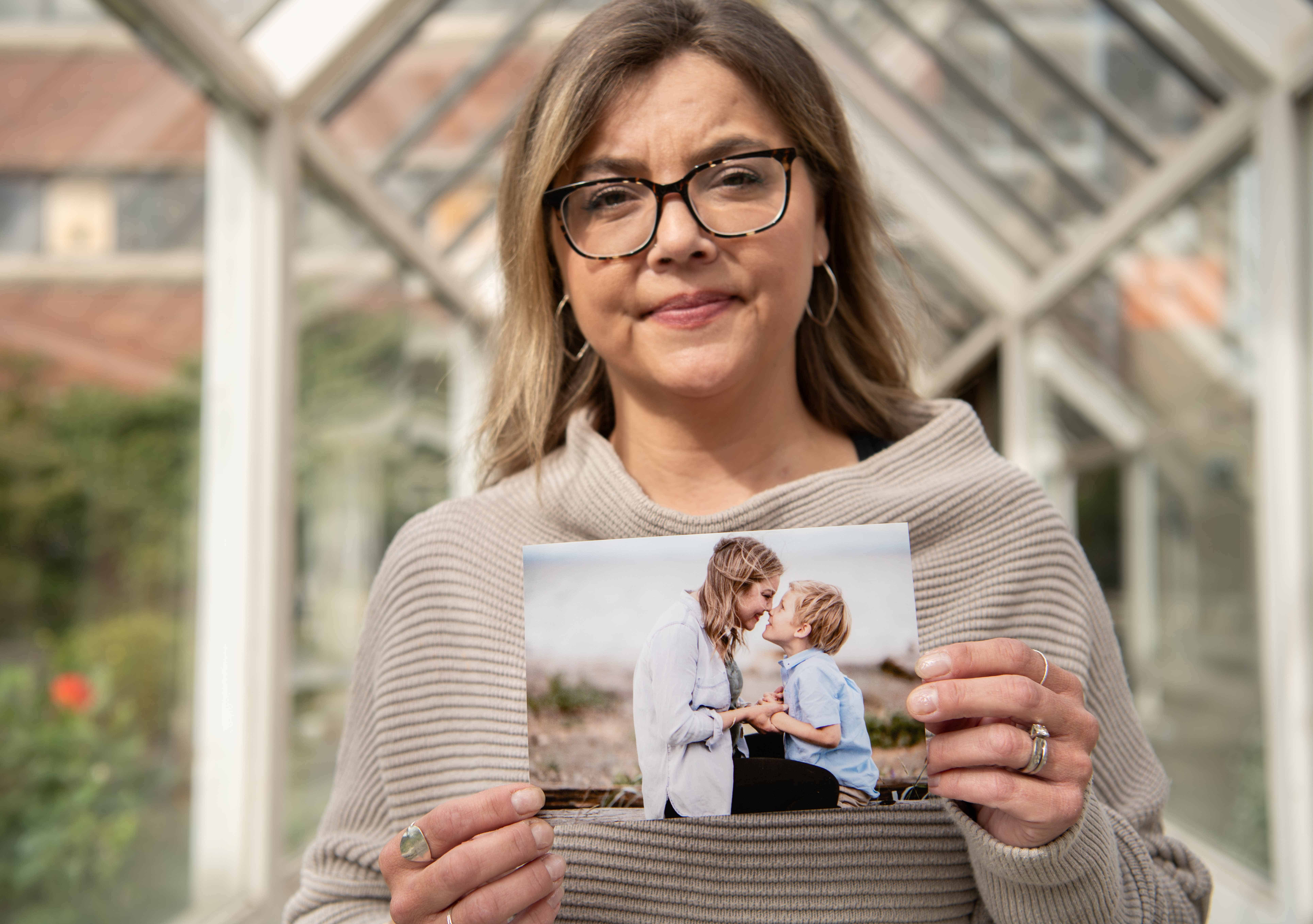 Kim Wood, grateful patient from Trikafta drug trial, holding an image of her and her son.