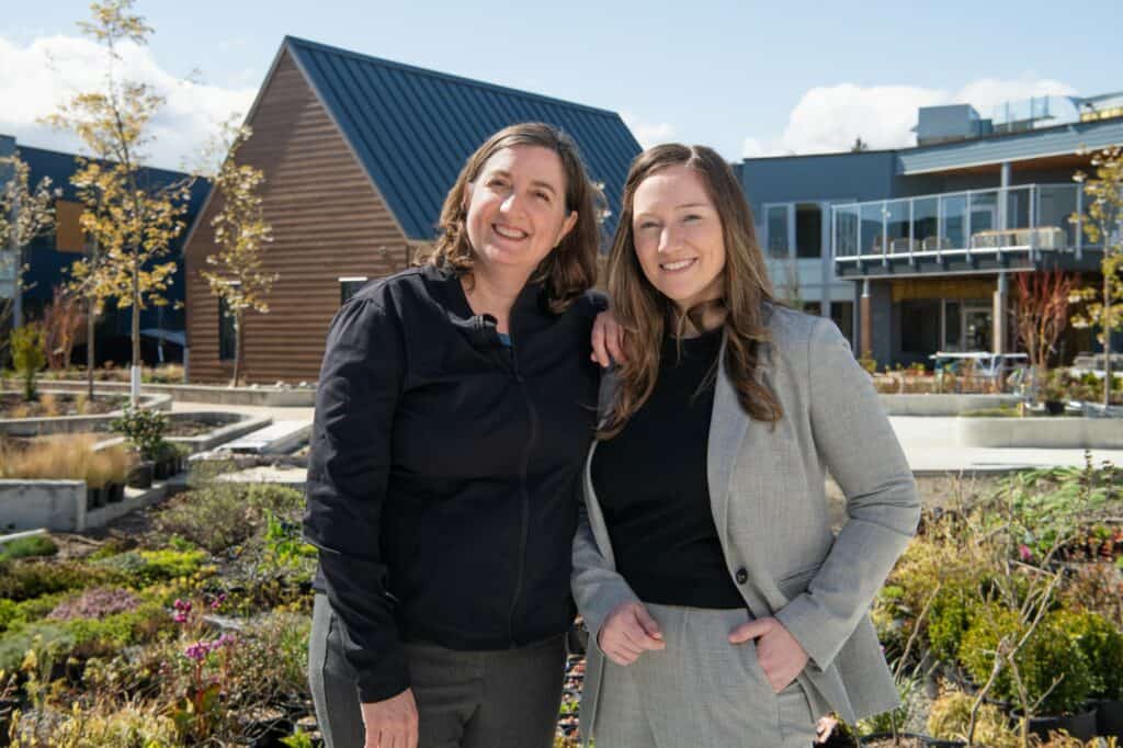 Joyce Shepherd, recreation therapist, Providence Living, and Dr. Jennifer Gibson, director of Quality, Practice, and Program Development, Providence Living, standing in the courtyard of The Views.