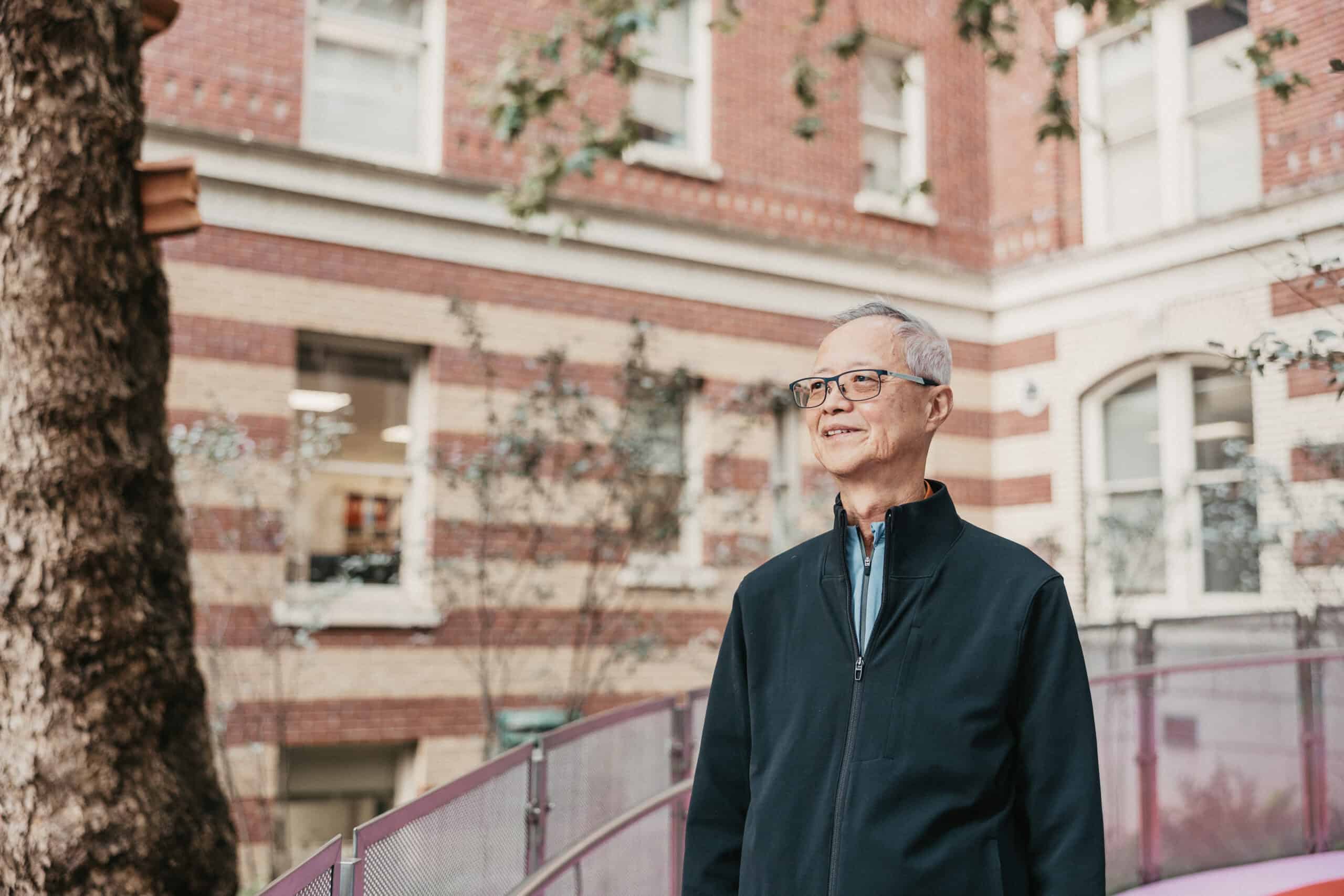 Man Hung, wearing a black top, in front of St. Paul's Hospital