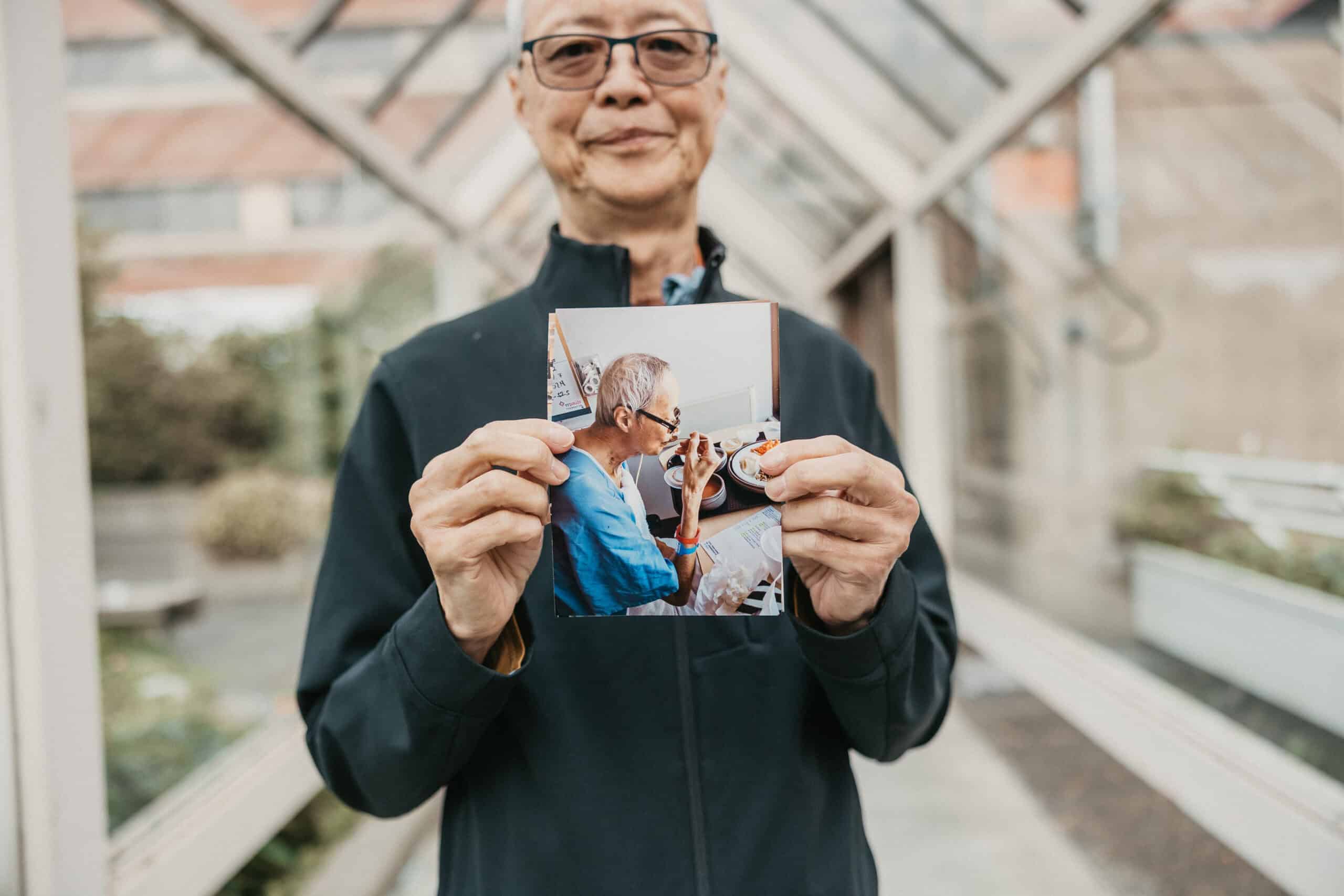 Man Hung holds a photo of himself during recovery.