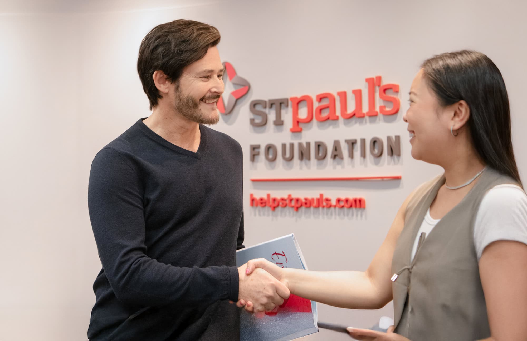 Staff shake hands at the St. Paul's Foundation office reception.