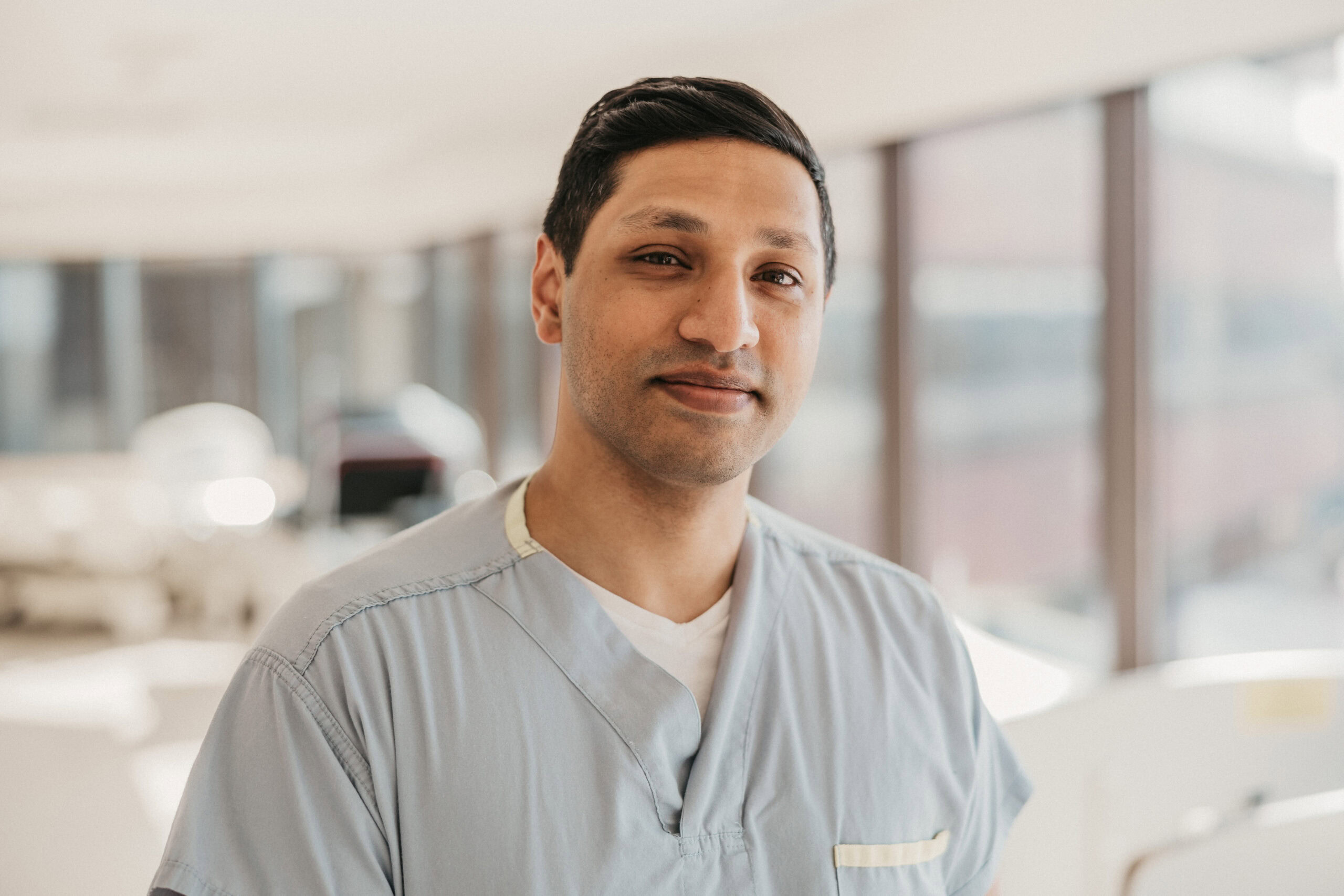Dr. Vishal Varshney, in scrubs, smiles at the camera.